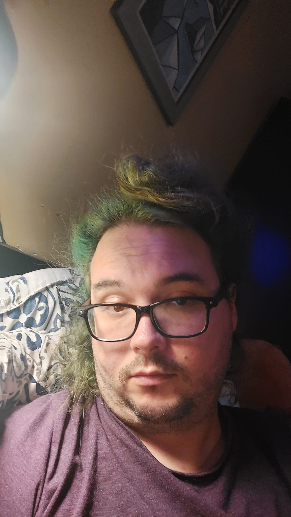 A man with long green hair and no beard lies in bed looking exhausted, Photo 2